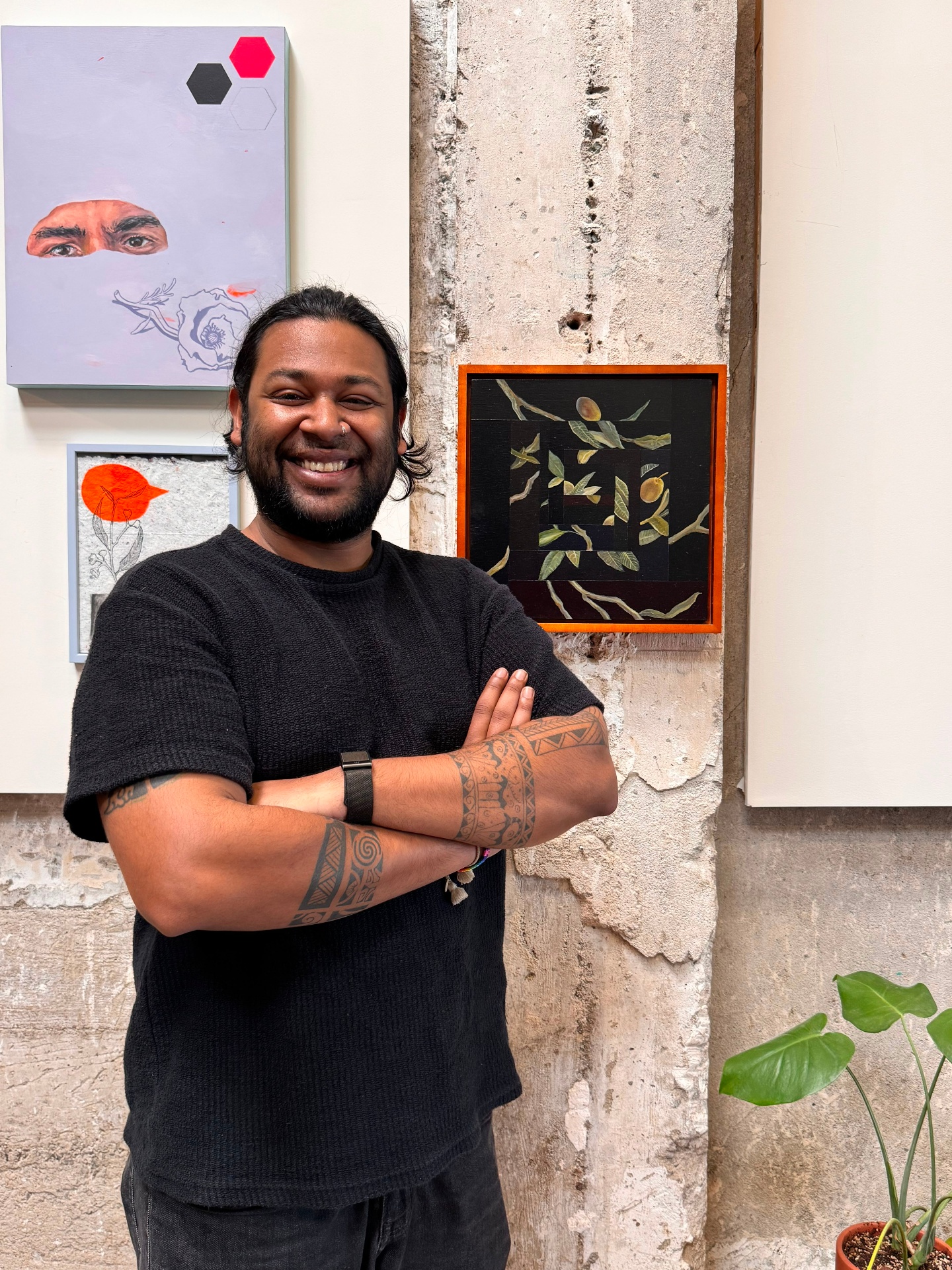 Moiz standing in front of an art wall, arms crossed